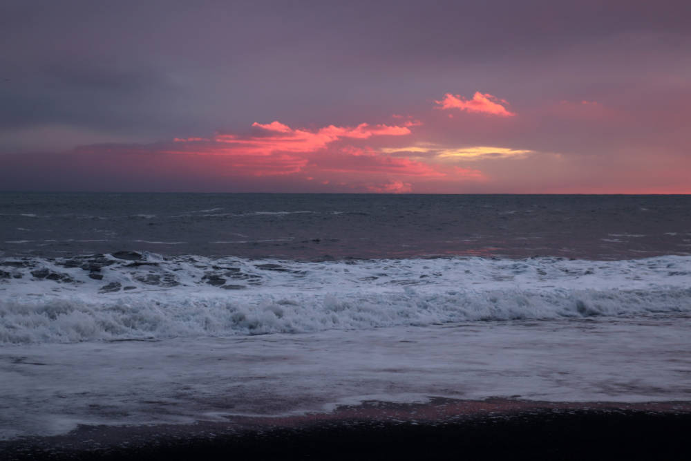 Pink Sunset Over Waves at Reynisfjara Black Sand Beach in Vik Iceland