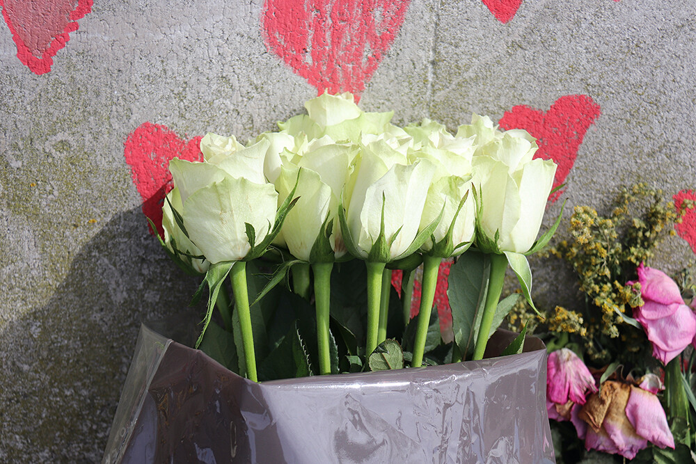 Fresh Flowers Against the London Wall of Red COVID Hearts