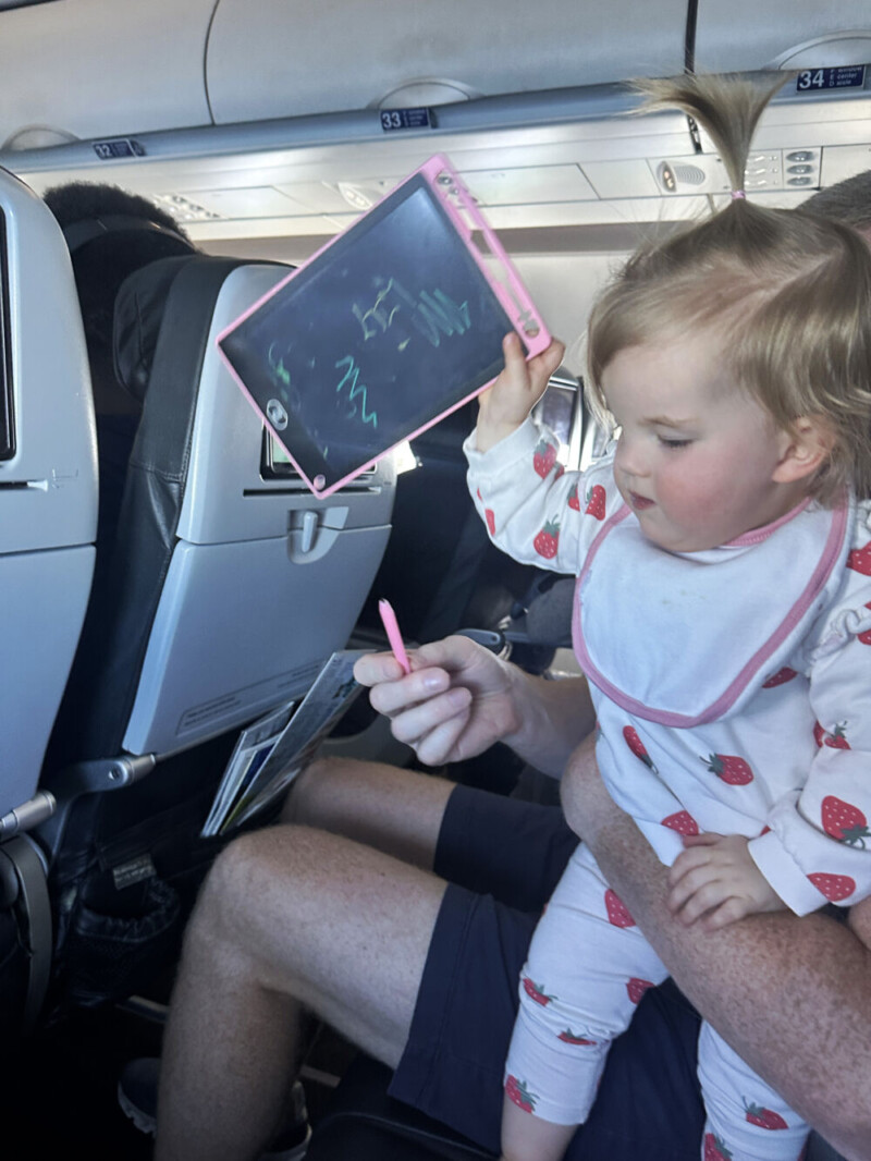 Lily on the Plane with her LCD Writing Tablet Doodle Board
