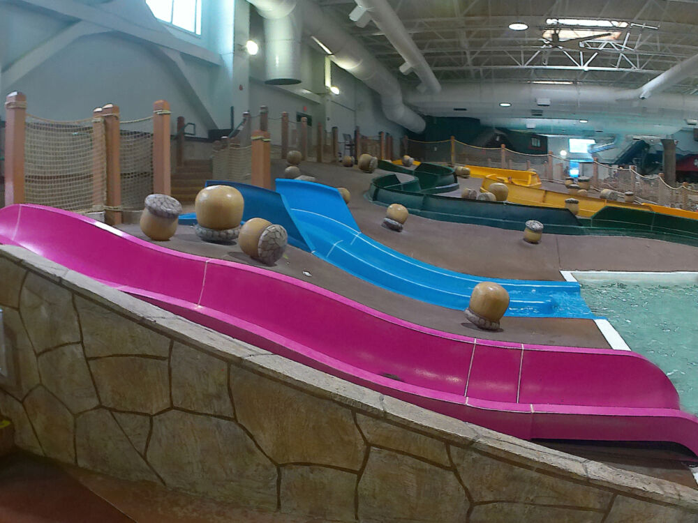 Multiple colorful beginner waterslides, including pink and blue options, designed for young children.