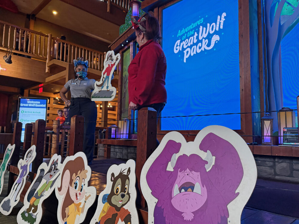 Resort staff members holding up character cutouts during an interactive story time session.