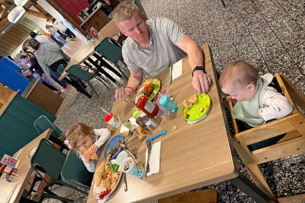 A family of four enjoying a buffet dinner together at a wooden dining table.