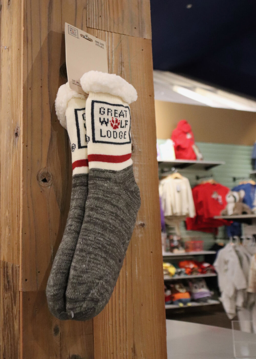 A pair of branded Great Wolf Lodge cozy socks hanging in a resort gift shop.