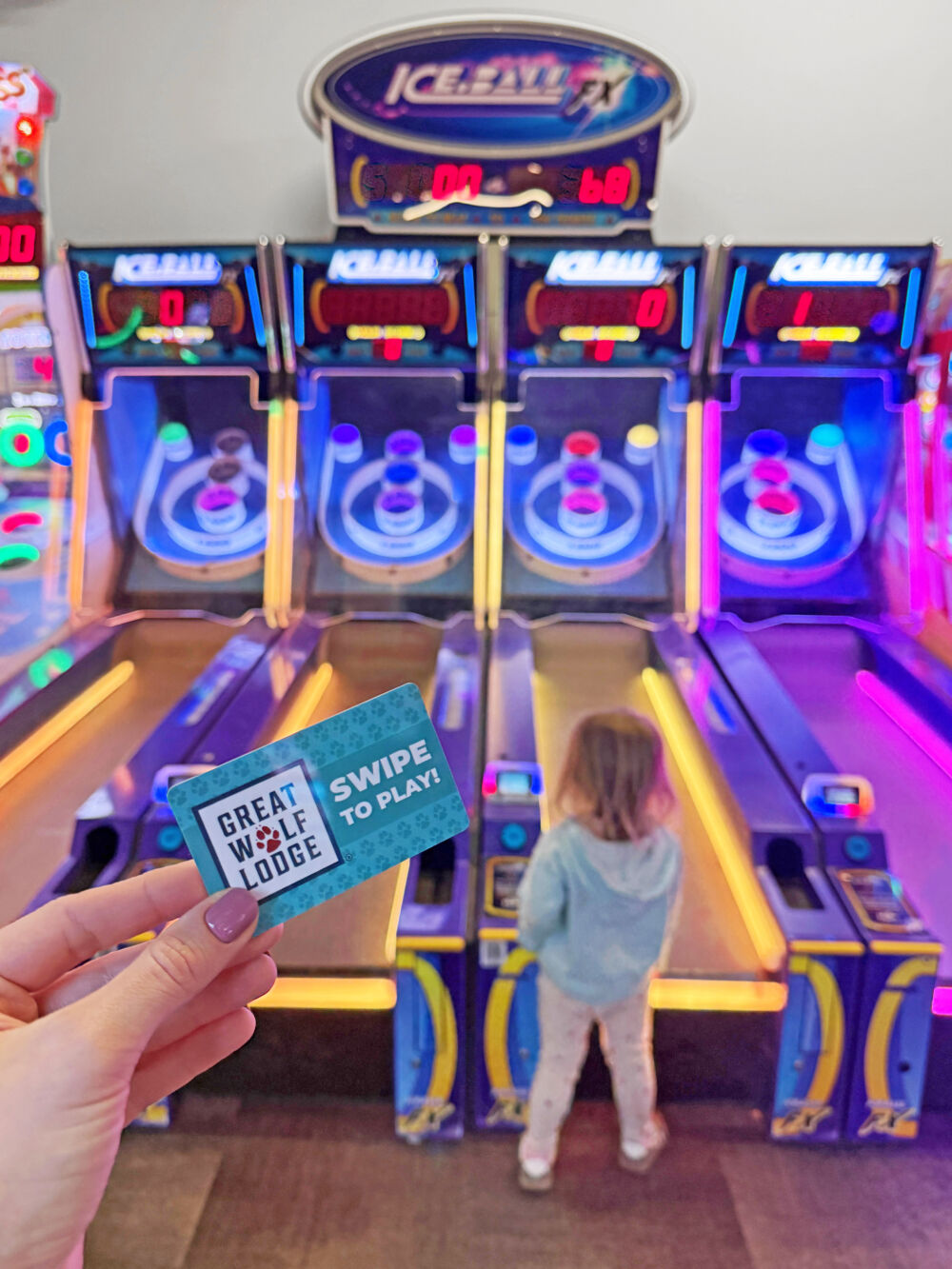 A toddler girl looking at Skee-Ball machines inside the Northern Lights Arcade.
